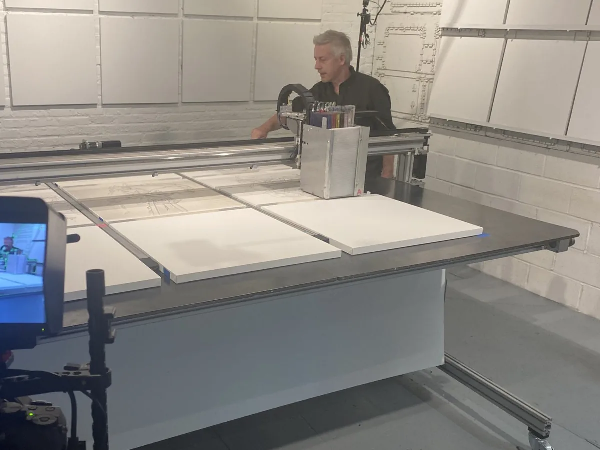 Matthew Ritchie at a Matr printer with a row of prepared panels